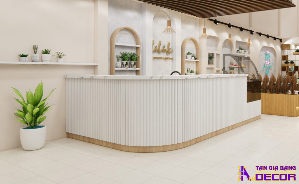 Tổng hợp 50 mẫu thiết kế quầy trà sữa đẹp! 37 Thiết kế quầy chữ L bo góc với tông màu cam theo lam nhựa trắng.
