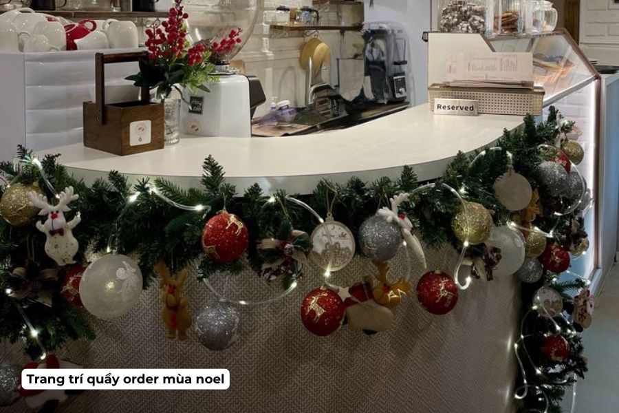 Ý tưởng trang trí Noel cho quán Cafe đẹp, hút khách năm 2026 9 Trang trí bằng nhánh thông và quả châu lên khu vực mép quầy order